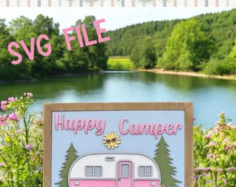 May include: A pink and white camper illustration with the words "Happy Camper" and a sun graphic. The image is set against a light blue background, framed in a wooden border, and includes the text "SVG FILE".