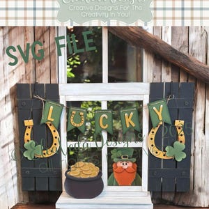 May include: A digital cut file for a St. Patrick's Day window decoration. The design features a green banner with the word "LUCKY" in gold letters, two gold horseshoes, a pot of gold, and a leprechaun.