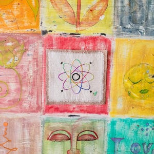 May include: A colorful, abstract painting with a white square in the center. The square has a colorful embroidered atom design inside.