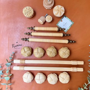 Könnte beinhalten: Ein Set aus geflochtenen Bambus-Schrank- und Schubladenknöpfen mit Messingakzenten. Die Knöpfe sind rund und die Griffe sind lang und schlank. Das Set umfasst verschiedene Größen und Stile.  "Kumru Home Design" steht auf einem kleinen Etikett.