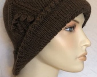 May include: A brown knitted cloche hat with a decorative knot on the side.