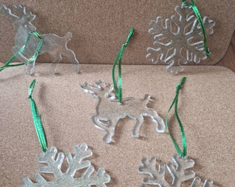 Könnte beinhalten: Sechs klare Acryl-Weihnachtsbaumschmuckstücke mit Glitzer. Es gibt zwei Rentiere und drei Schneeflocken. Jedes Ornament hat ein grünes Band.