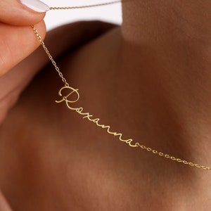 May include: A gold chain necklace with the name "Roxana" written in cursive script.