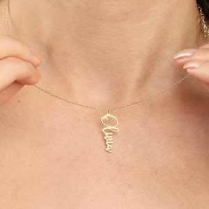 May include: A gold necklace with a delicate chain and a pendant featuring the name "Olivia" written in a cursive script.