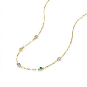 May include: A delicate gold necklace featuring a series of colorful gemstones. The necklace has a fine chain and is adorned with round gemstones in yellow, blue, green, and clear. The gemstones are evenly spaced along the chain, creating a subtle and elegant design.