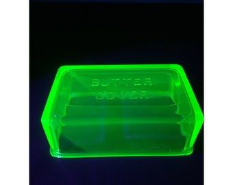 May include: A vintage green glass butter dish with the words "Butter Cover" embossed on the top.