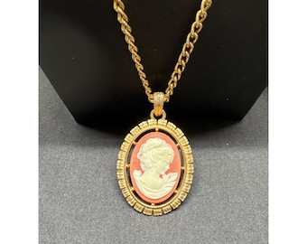 Collar vintage de Avon de los años 70 con colgante reversible tipo camafeo y un elaborado diseño de flor de lis en tono dorado.