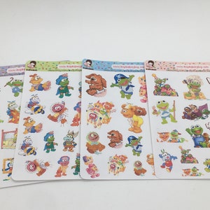 May include: Four sheets of Muppet Babies stickers featuring various characters in colorful designs. The stickers showcase Kermit the Frog, Miss Piggy, Fozzie Bear, and other Muppet Babies characters in playful poses. The sheets have a white background.
