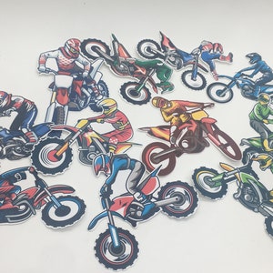 May include: A set of 10 colourful motocross rider and dirt bike stickers. The stickers feature riders in various poses and colours, with detailed designs of the bikes and riders' gear.