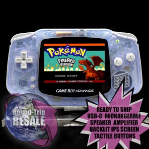May include: A transparent blue Game Boy Advance handheld console displaying the Pokémon FireRed Version game. The console has a backlit IPS screen and tactile buttons. The screen shows a red dragon graphic. The console has a D-pad, A and B buttons, and start and select buttons.
