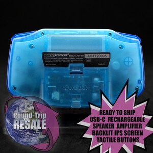 Op de afbeelding: Een doorschijnende blauwe Game Boy Advance handheld-gameconsole met de tekst "GAME BOY ADVANCE" en "GAME BOY" gedrukt op de achterkant. De console heeft een modelnummer "AGB-001" en een serienummer "AH1720005".