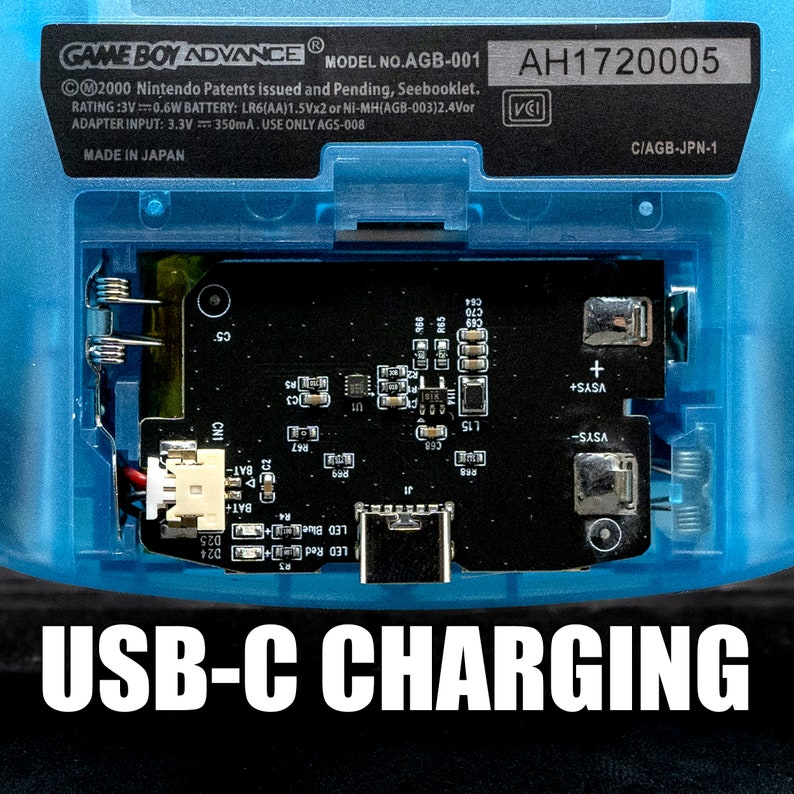 Puede incluir: Primer plano de una Game Boy Advance azul con un puerto de carga USB-C. El texto "USB-C CHARGING" est&aacute; impreso en blanco en la parte inferior de la imagen. El n&uacute;mero de serie "AH1720005" est&aacute; impreso en la esquina superior derecha de la imagen.
