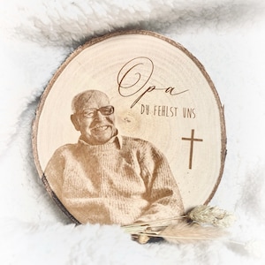 Puede incluir: Una placa conmemorativa de madera con una foto de un hombre y el texto "Opa Du Fehlst Uns" y una cruz.