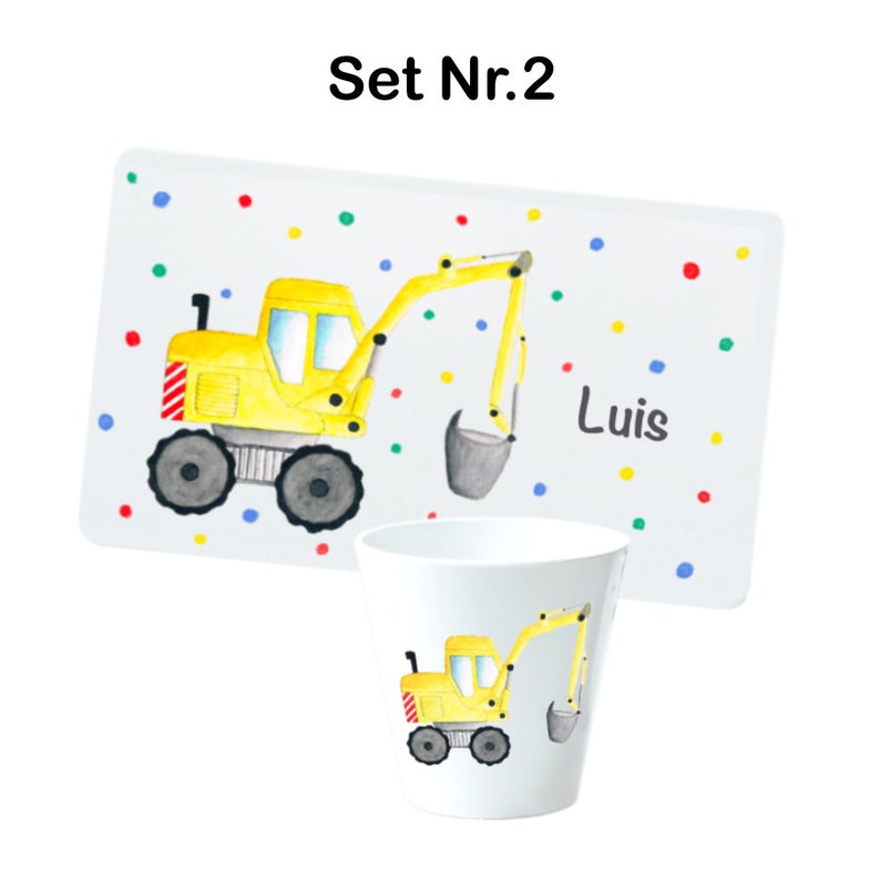 May include: A yellow toy excavator with a gray bucket is on a white plate with colorful dots. The plate has the name "Luis" written on it. The set also includes a white cup with the same excavator design.