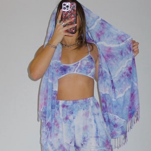 May include: A tie-dye print set featuring a crop top and wide-leg pants. The set is in shades of blue and purple with a white background.