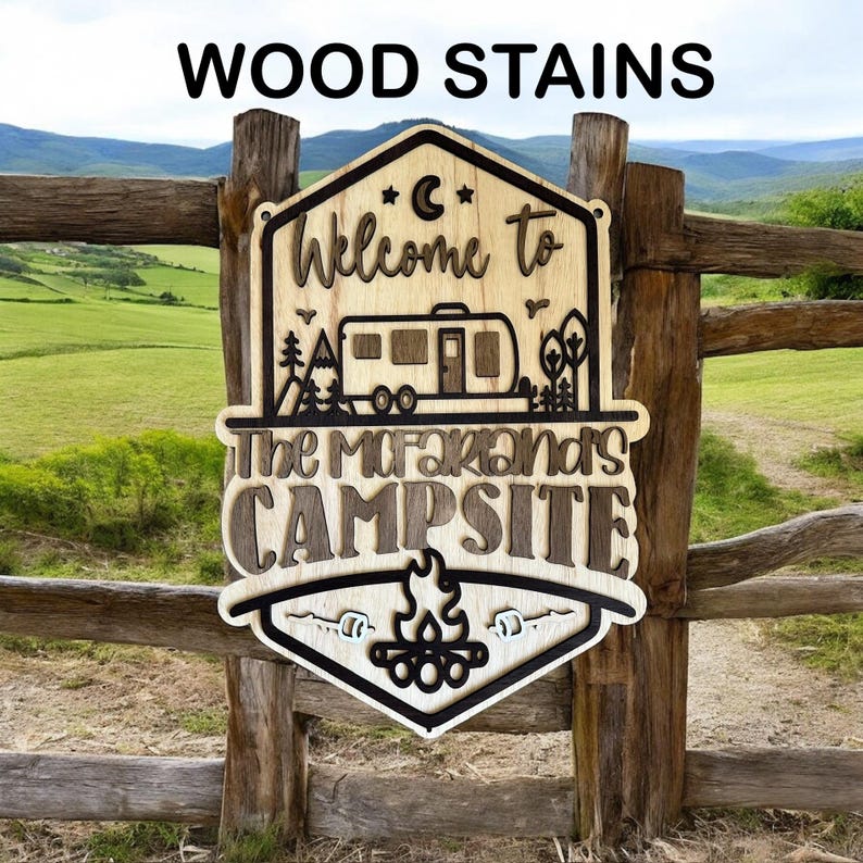 May include: A wooden sign with a rustic brown stain, featuring a welcome to campsite design. The sign has a camper silhouette, a campfire, and the text "The McFarlands Campsite".