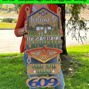 May include: Wooden campsite sign with a welcome to the Zalke family campsite message, a camper silhouette, a campfire, and a personalized nameplate with the names Mark, Amy, and Charlie and the number 609.