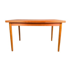 May include: A rectangular wooden dining table with four tapered legs. The table is a warm, medium brown colour and appears to be made of solid wood. The table has a simple, mid-century modern design.