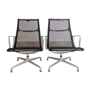 May include: Two modern office chairs with black mesh backs and seats. The chairs have silver-colored armrests and five-star bases. The chairs are designed for comfort and support, suitable for a home or office setting.
