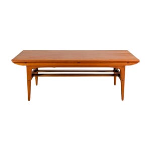 May include: A rectangular wooden coffee table with a warm brown finish. The table has a two-tiered design with a lower shelf and tapered legs. The table is approximately 48 inches long, 20 inches wide, and 16 inches high.