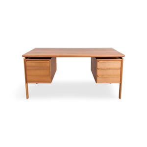 May include: A rectangular wooden desk with a light brown finish. The desk features a flat top surface supported by four legs. On the left side is a single cabinet door, and on the right side are three stacked drawers with horizontal wooden handles.