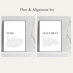 Op de afbeelding: Een set van twee ingelijste kunstprints. De linkerprint leest "FLOW" met een definitie. De rechterprint leest "ALIGNMENT" met een definitie. Beide prints hebben zwarte tekst op een witte achtergrond.