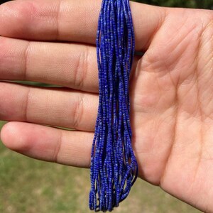 May include: A strand of deep blue lapis lazuli beads, approximately 38 cm long. The beads are small and round, with a smooth, polished finish.