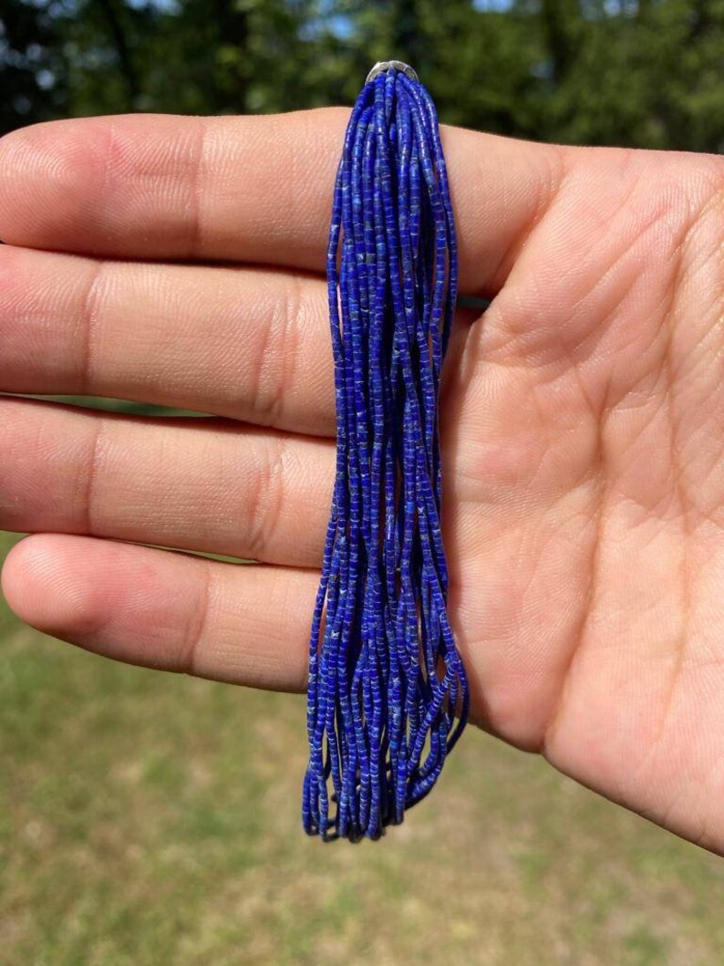 May include: A strand of deep blue lapis lazuli beads, approximately 38 cm long. The beads are small and round, with a smooth, polished finish.