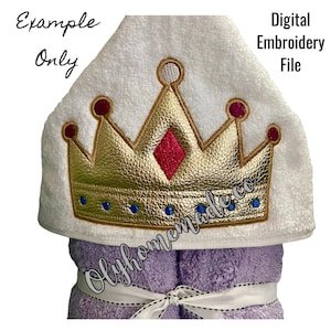 May include: A white hooded towel with a gold crown embroidered on the hood. The crown has a red diamond in the center and blue gems around the edge. The towel is folded and tied with a white ribbon.