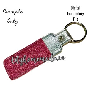 May include: Pink and silver glitter key fob with a silver metal ring and the text "Olyhomemade.co".