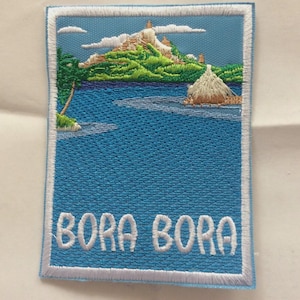Peut inclure: Écusson brodé représentant une scène d'île tropicale avec un lagon bleu, des collines vertes et une hutte au toit de chaume. Le texte "BORA BORA" est brodé en blanc. L'écusson a une bordure blanche.