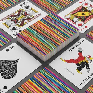 May include: A deck of playing cards with a colorful striped design on the back. The deck includes a Joker card with a red and black costume and the text "Joker" and "Made in USA".