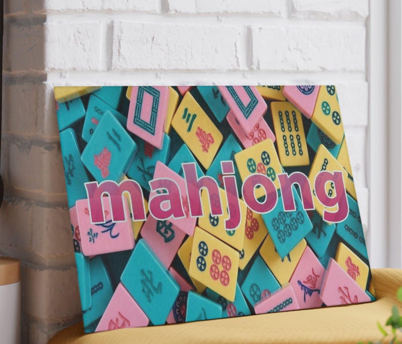 May include: A rectangular wall art print featuring a colorful collage of mahjong tiles in shades of pink, yellow, and teal. The word mahjong is printed in large, bold, magenta letters across the center of the tile pattern.