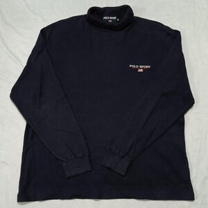May include: A navy blue long-sleeve mock neck shirt featuring the text POLO SPORT and a small American flag graphic embroidered on the chest. The inner collar label also displays the text POLO SPORT with a small American flag graphic.