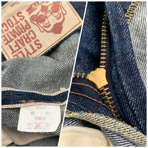 Pu&ograve; includere: Primo piano di un paio di jeans blu in denim con una cerniera in ottone e un'etichetta rossa con la scritta "STYLE CRAFT PRIVATE STOCK" con un personaggio dei cartoni animati con occhiali da sole. L'etichetta ha anche il testo "SIZE 37". I jeans hanno un'etichetta di cura bianca con testo giapponese e un simbolo di istruzioni di lavaggio.