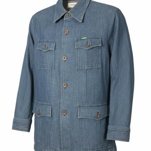 May include: A light blue denim jacket with four front pockets and wooden buttons. The jacket has a collared neckline and a small green tag on the upper pocket. The jacket is a classic style.