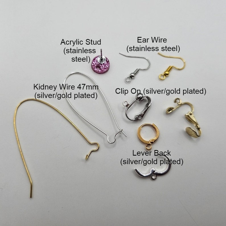 Op de afbeelding: Assortiment van oorbelbeslag, waaronder een roze acryl stud, oorhaakjes, nierdraadjes, clip-on oorbellen en hefboomsluitingen. Alle beslag is verkrijgbaar in zilveren of vergulde afwerkingen.