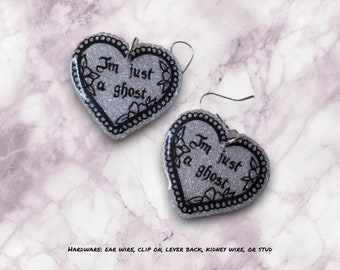 May include: Silver glitter heart-shaped earrings with black text that reads "Im just a ghost".
