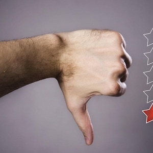 Könnte beinhalten: Eine Hand zeigt einen Daumen nach unten mit einer Reihe von fünf weißen Sternen darüber, wobei der unterste Stern rot hervorgehoben ist.
