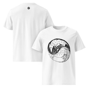 May include: White t-shirts with a black and white graphic design. The design features a circular yin-yang style illustration with a wolf and a woman. The back of the shirt has a small black circular logo.