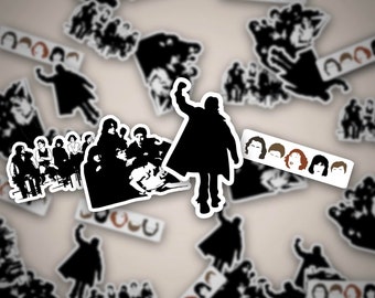 May include: A black and white sticker sheet featuring a group of people sitting on a couch, a single person standing with arms raised, and a row of faces with different hairstyles. The sticker sheet is on a light brown background.