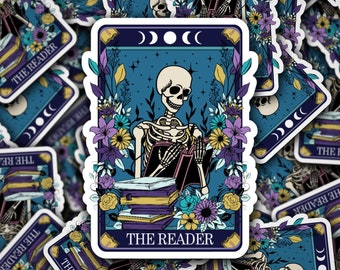 May include: A tarot card illustration featuring a skeleton reading a book surrounded by flowers and a stack of books. The card is titled "The Reader" and has a crescent moon design in the top corners.
