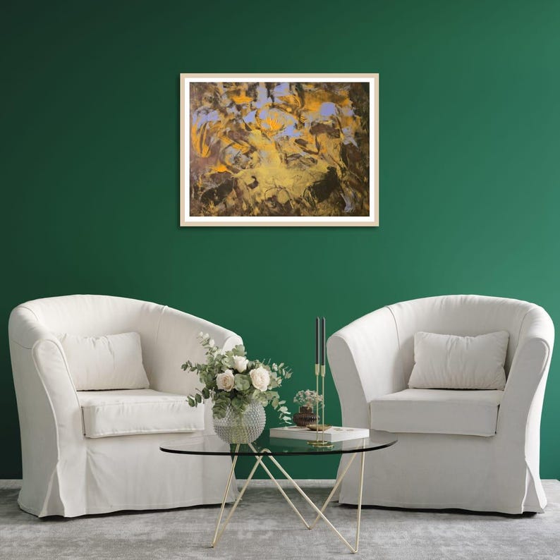 Puede incluir: Una pintura abstracta en un marco de madera clara cuelga de una pared verde oscuro. La obra presenta una mezcla de tonos dorados, marrones y azules. Dos sillones blancos con cojines a juego est&aacute;n colocados debajo, con una mesa de centro de cristal en medio.