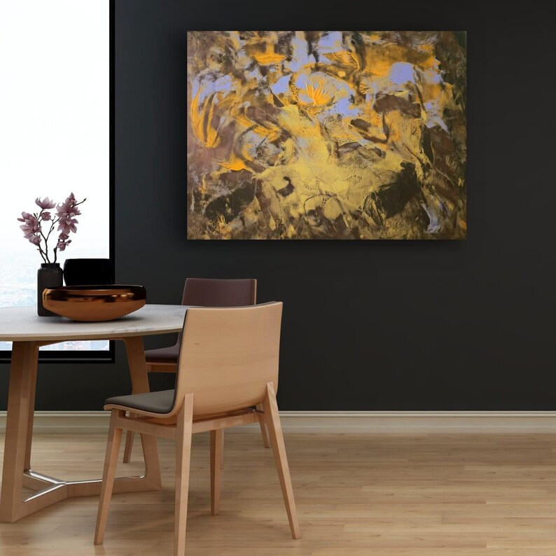 Puede incluir: Pintura abstracta con una mezcla de colores, incluyendo dorado, marr&oacute;n y lavanda. La obra de arte se exhibe en una pared oscura sobre una mesa de comedor con sillas de madera. Un cuenco decorativo y un jarr&oacute;n con flores est&aacute;n sobre la mesa.