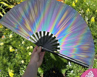 May include: A black and silver iridescent folding fan with a black handle. The fan is open and the iridescent material creates a rainbow effect.