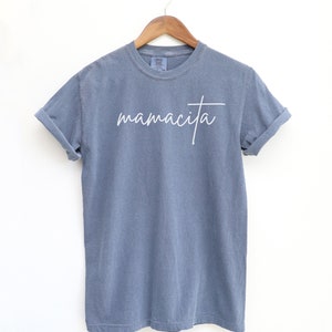May include: A blue t-shirt with the word "mamacita" written in white cursive on the front.