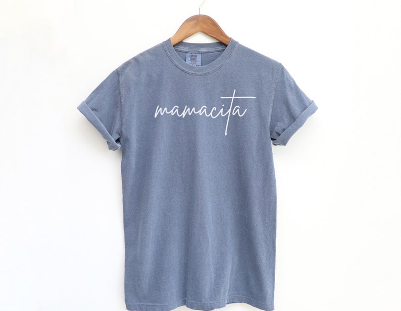 May include: A blue t-shirt with the word "mamacita" written in white cursive on the front.