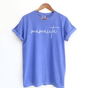 May include: A blue t-shirt with the word "mamacita" written in white cursive on the front.