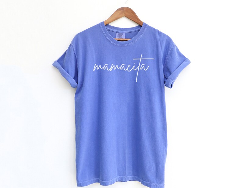 May include: A blue t-shirt with the word "mamacita" written in white cursive on the front.