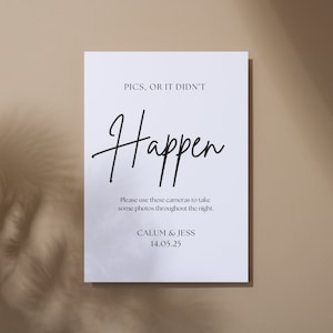 May include: A white sign with black text. The text reads "PICS, OR IT DIDN'T Happen." Beneath, it says "Please use these cameras to take some photos throughout the night." The sign is for Calum & Jess, dated 14.05.25.